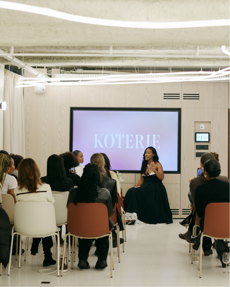 A Koterie salon with attendees listening to a panel discussion.